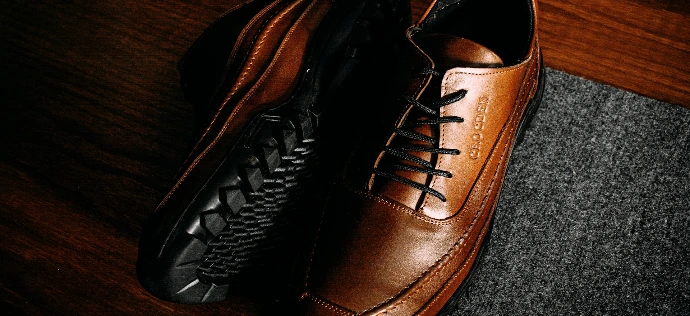 a pair of brown shoes sitting on top of a wooden floor